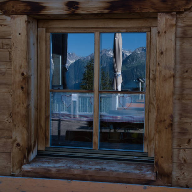 istock Reflection in old window with banks and mountains 1159237575