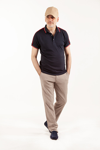 Senior man in cotton pants and polo shirt isolated on white background. Summer outfit. Stylish old men.