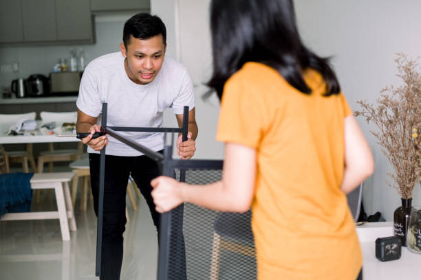 istock Young Couple Moving in New House Assembling Table 1159237845