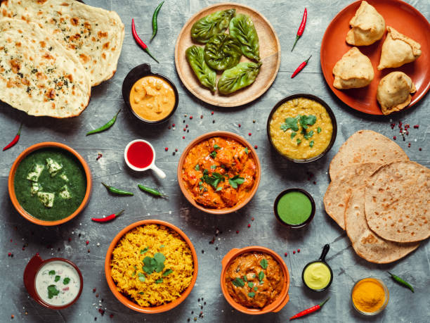 Indian food and indian cuisine dishes, top view Indian cuisine dishes: tikka masala, dal, paneer, samosa, chapati, chutney, spices. Indian food on gray background. Assortment indian meal top view or flat lay. indian food stock pictures, royalty-free photos & images