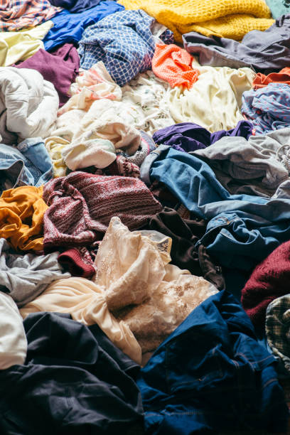 istock pile of used clothes on a light background. Second hand for recycling 1159239984