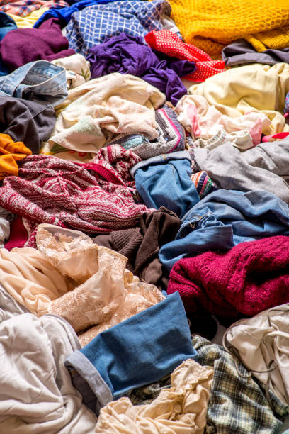istock pile of used clothes on a light background. Second hand for recycling 1159239987