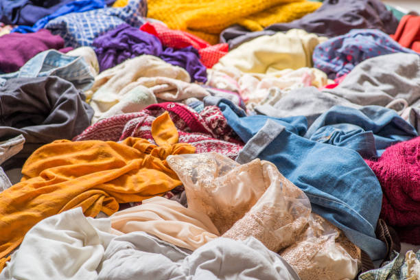 istock pile of used clothes on a light background. Second hand for recycling 1159239988