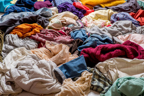 istock pile of used clothes on a light background. Second hand for recycling 1159239989