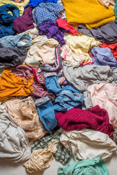 istock pile of used clothes on a light background. Second hand for recycling 1159240006
