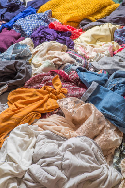 istock pile of used clothes on a light background. Second hand for recycling 1159240007