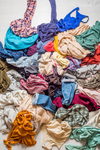 istock pile of used clothes on a light background. Second hand for recycling 1159240009