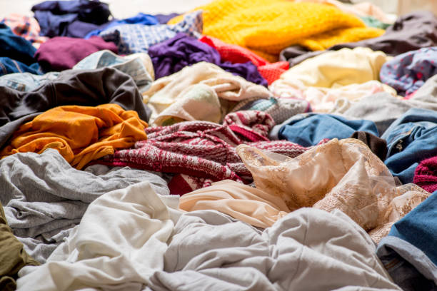 istock pile of used clothes on a light background. Second hand for recycling 1159240013