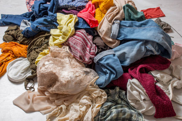 istock pile of used clothes on a light background. Second hand for recycling 1159240015