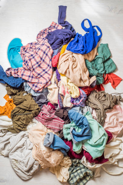 istock pile of used clothes on a light background. Second hand for recycling 1159240021