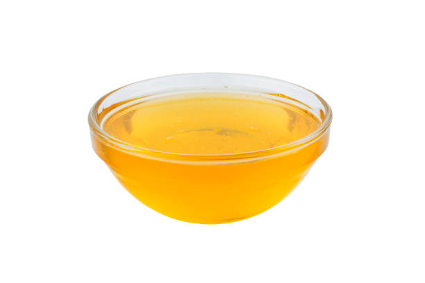 istock Honey in glass bowl isolated on white background 1159240310