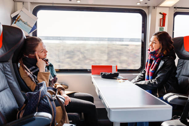 Two woman Friends talks and laughing while travel by train