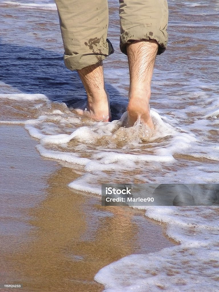 Uomo camminare barefood sulla spiaggia - Foto stock royalty-free di Mare