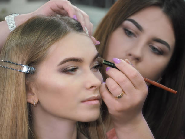 istock Make-up artist makes make-up at the female models face  close-up 1159242344