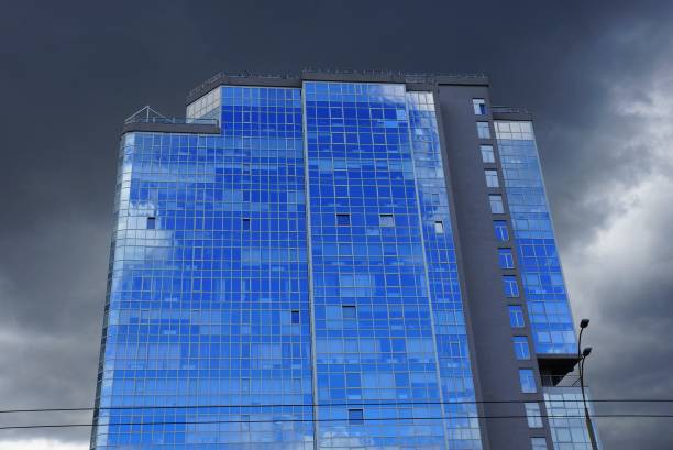 istock blue multi-storey glass house on a background of gray clouds 1159243737