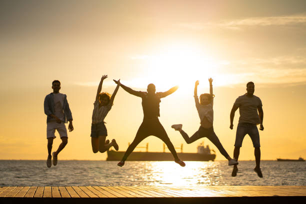 istock Playful friends jumping at sunset 1159247303