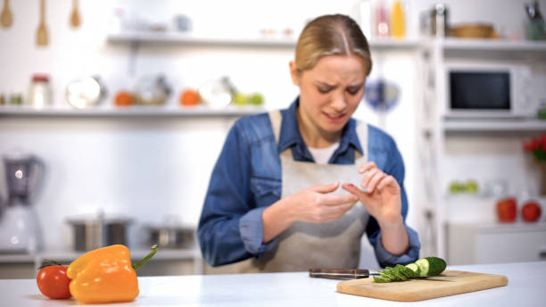 female cut finger while slicing cucumber, accident in kitchen, household injury - wound blood human finger human hand imagens e fotografias de stock