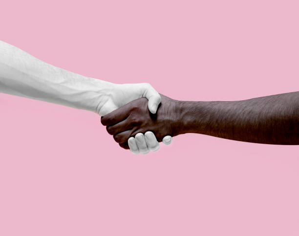istock Pure white and pure black (painted) hands shaking together. 1159253910