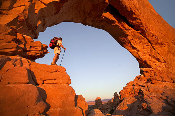 wanderer im rock arch looking at view - moab stock-fotos und bilder