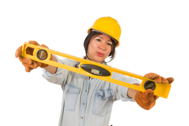istock Hispanic Female Contractor Holding Level Wearing Hard Hat Isolated on White Background 1159259589