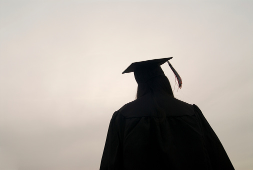 Silhouette of a female graduate looking up.