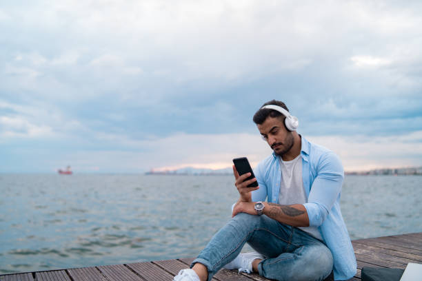 istock Handsome man enjoying music at seaside 1159263478