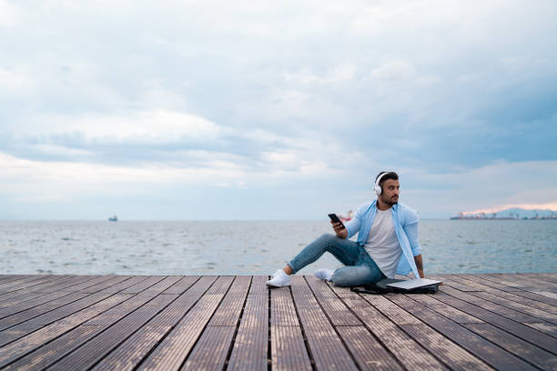 istock Handsome man enjoying music at seaside 1159263512