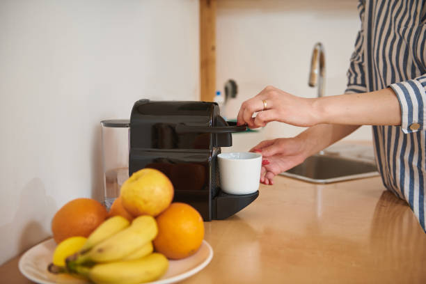 istock Young woman making delicious coffee in kitchen at home 1159263514
