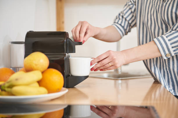 istock Young woman making fresh coffee in kitchen at home 1159263515