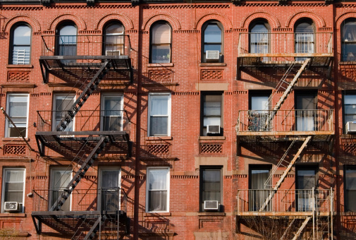 Exterior of apartment building with prominent fire escapes. Image taken in Manhattan. 
