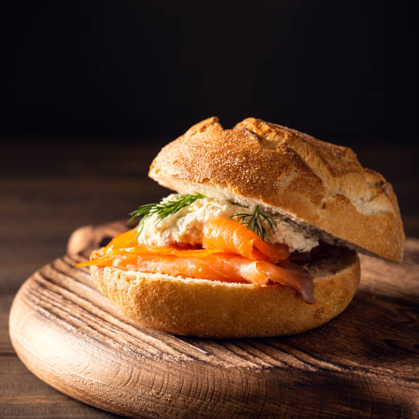 Sandwiche with salmon and herb butter on old wooden table. Healthy food background concept with copy space