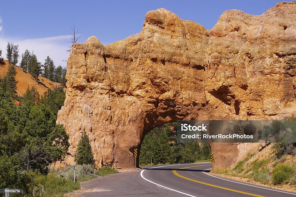 redrock sandstone with bright oranges and yellows, years of erostion road tunnel Blue Stock Photo