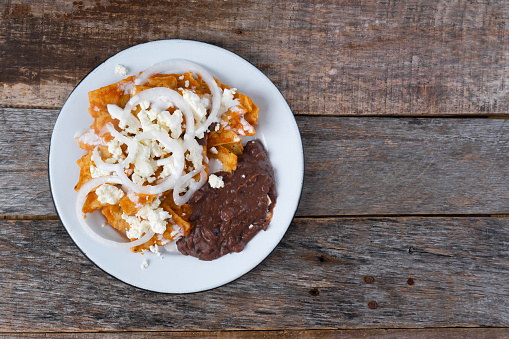Mexican food: Red chilaquiles with cheese and beans