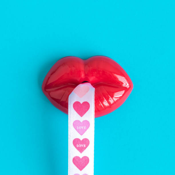 Plastic red lips and heart design ribbon. Sending kisses and love minimal creative concept.