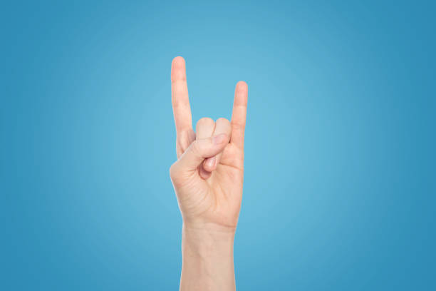 istock Hand show rock gesture on a blue background, close up. 1159267770