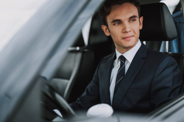 istock Happy handsome guy sitting behind wheel of car 1159270161