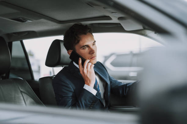 istock Young handsome guy sitting in his car with smartphone 1159270164
