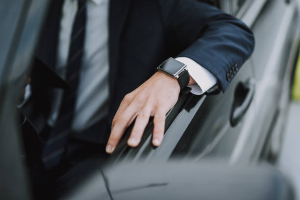 istock Man in black suit sitting in his car 1159270168