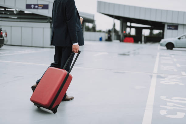 istock Young guy with coffee in suit walking on the parking lot 1159270204
