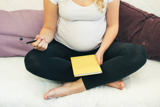 istock Pregnant woman writing in a diary 1159270420