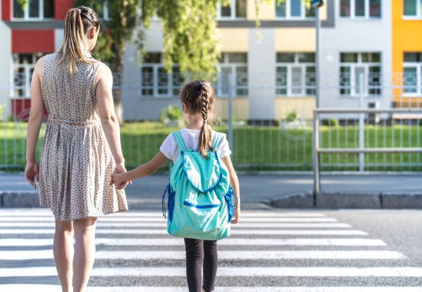 istock Back to school education concept with girl kids, elementary students, carrying backpacks going to class 1159273187
