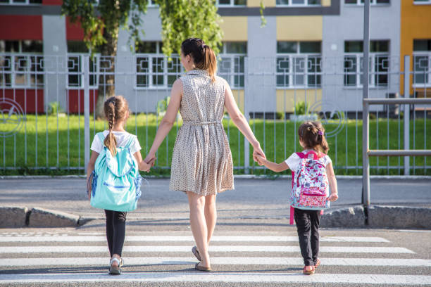 istock Back to school education concept with girl kids, elementary students, carrying backpacks going to class 1159273188