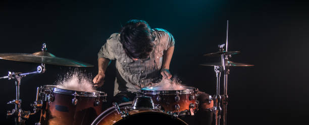 musicista che suona la batteria con schizzi, sfondo nero con bella luce soffatta - drum roll foto e immagini stock