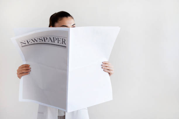 istock Woman reading newspaper on white background 1159289048