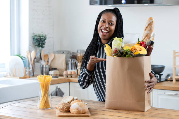 istock Woman with grocery bag in kitchen 1159293087