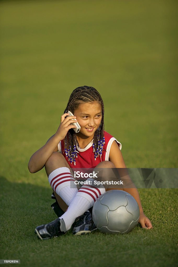 Adolescente con il cellulare sul campo da calcio (calcio - Foto stock royalty-free di 14-15 anni