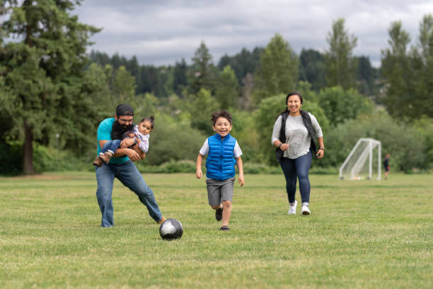 gioco di calcio per famiglie! - football player group of people running american football foto e immagini stock