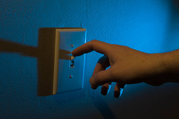 turning off the lights with finger - startknop stockfoto's en -beelden