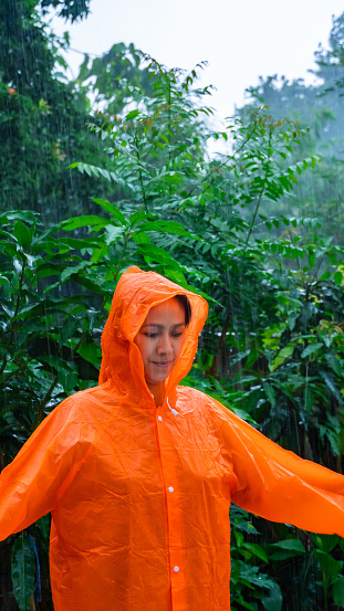 Woman wearing orange raincoat out in the rain