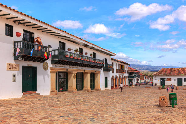 Villa de Leyva, Colombia - The South Western Side and Western Corner Of The Cobblestoned Plaza Mayor In The Historic 16th Century Colonial Town of Villa de Leyva, in The Boyacá Department, In The Morning Sunlight Villa de Leyva, Colombia - September 14, 2014: looking down Calle or Street 12 towards the Western corner of the cobblestoned town square on a sunny Sunday morning. It looks as if time has stood still in this town for about 450 years. In the far background are the Andes Mountains, the Cordillera Oriental. Founded in 1572 and located at an altitude of just over 7000 feet above mean sea level on the Andes Mountains Villa de Leyva was declared a National Monument by the Colombian Government in 1954 to protect its colonial architecture and heritage. It is located in the Department of Boyacá, in the South American country of Colombia. The Town was one of the locations for the movie Cobra Verde by Werner Herzog and the Spanish language Soap Opera Zorro. Photo shot in the morning sunlight; horizontal format. Copy space. boyacá department photos stock pictures, royalty-free photos & images